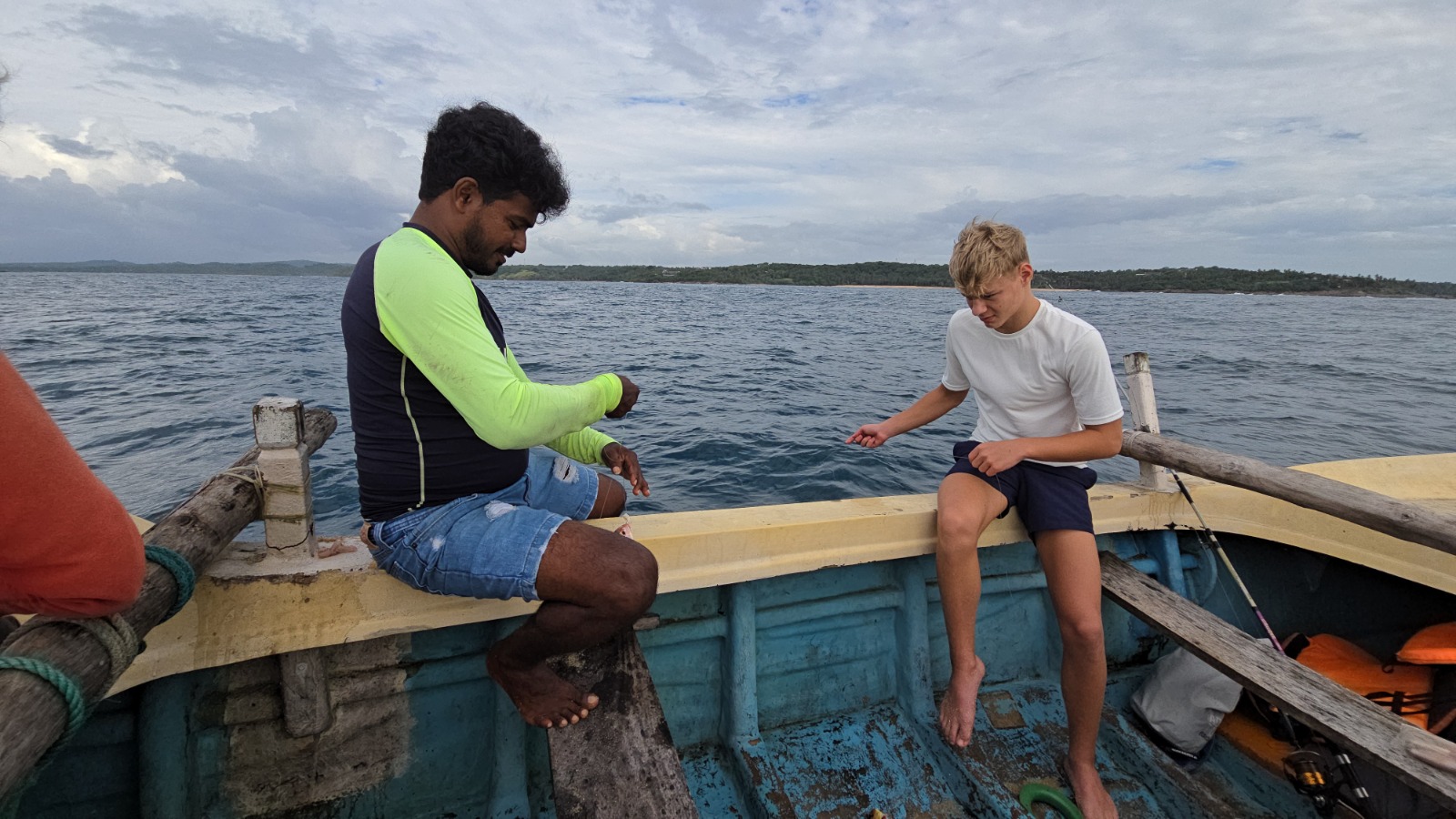 Local guide helping a guest rig a fishing line